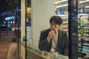 저녁 시간 편의점에서 삼각김밥으로 식사를 하는 30~40대 남성의 모습. 소득 감소로 생활비 부담을 느끼는 지역가입자의 상황을 표현한 이미지.